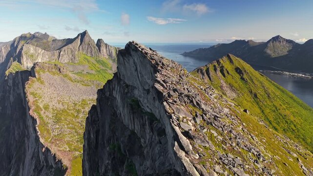 Aerial view of Segla mountain peak and ocean near coastal area in Norway during daytime with clear sky. Fly around mountain Segla, Senja island