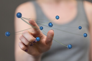 Close-up of a hand touching connected spheres, symbolizing digital connection, communication and technology, wi