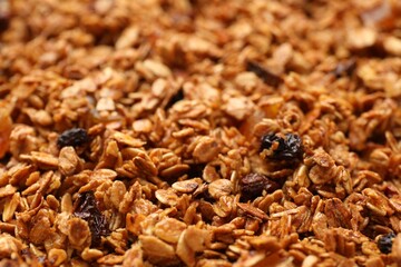 Tasty granola with dried fruits as background, closeup