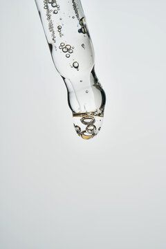 Cosmetic pipette dispensing serum with bubbles macro shot