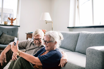 Senior couple laughing during video call at home