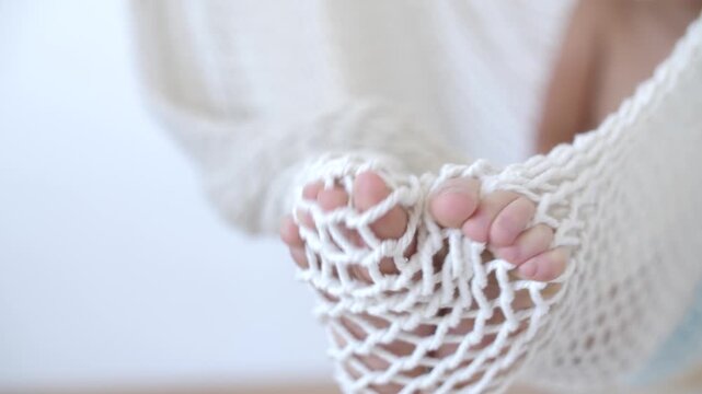 Close-up of baby's tiny feet resting in hammock moving toes.