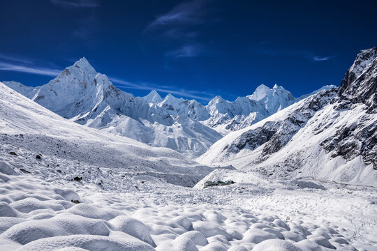 Himalaya mountains in sunny day after snowfall. Mt. Ama Dablam, Kangtenga, Thamserku and others behind snow covered slopes and Thokla (Dughla) group of lodges. View from the way to Dughla pass.