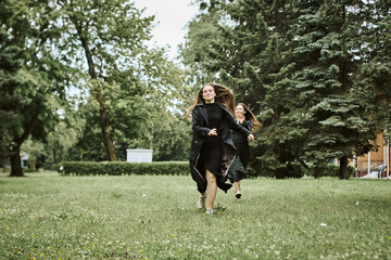 Young women running through green park on cloudy day