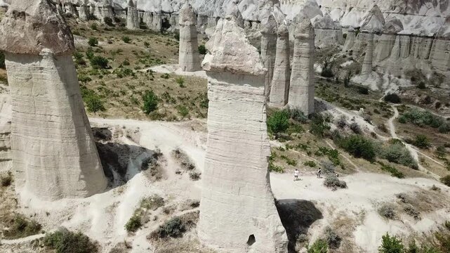 From above, the drone reveals Cappadocia&rsquo;s famous naturally sculpted phallic rock spires, standing prominently against the rugged terrain.