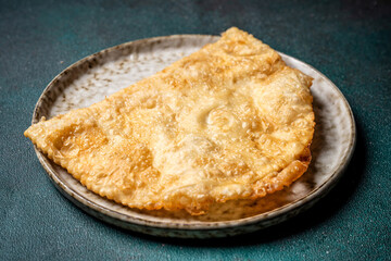 Single crispy halal tatar cheburek on ceramic plate