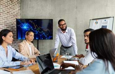 Colleagues from various backgrounds engage in a conference meeting in a modern boardroom. They brainstorm and discuss company strategy with an emphasis on collaboration and diversity.