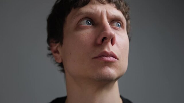 Paranoia and hypervigilance, man anxiously looking around in fear of unseen threat. Close up portrait of a nervous man