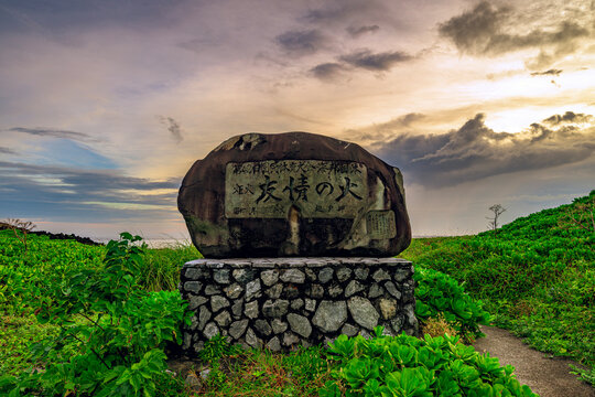 夕暮れの光に包まれた辺戸岬の友情の火記念碑の風景