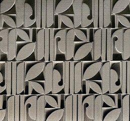 Close up of 3D carving in geometrical round leaves and rounded shape, carved on grey material. Suitable for wall panel decoration, and interior elements. Seamless background texture