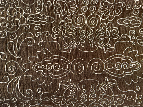 Traditional ethnic fabric in random abstract ornamental swirls and paisley pattern. In brown and white color. Classic ethnic dyed cloth. Seamless background texture.