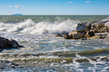 The rough sea - Storm with waves and barrier of rocks to protect from the waves