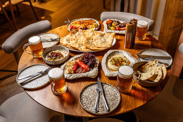 Tatar halal feast with chebureki and beer on wooden table