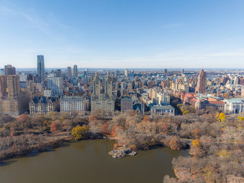 Aerial view of Central Park's serene lake reflecting the sky, framed by the iconic San Remo towers and the distant skyscrapers, Manhattan, New York, United States.