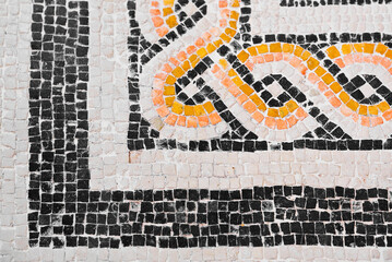 Ancient Italian Roman mosaic floor with geometric shapes composed of small colored stone tiles