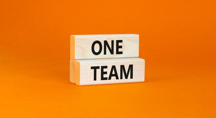 One team symbol. Concept word One team on beautiful wooden blocks. Beautiful orange paper background. Business one team concept. Copy space.