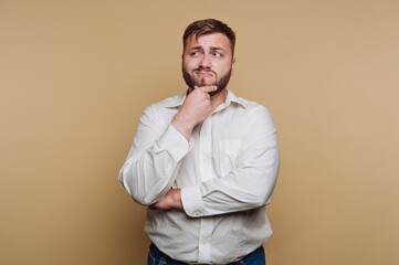 Fototapeta premium Man in white shirt pondering against beige background