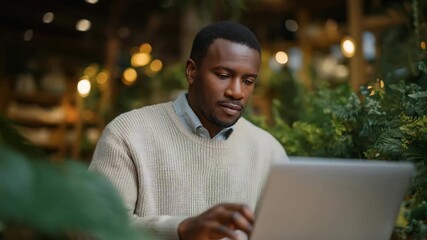 Refugee small business owner using a laptop to manage online sales in a cozy shop, highlighting digital entrepreneurship, integration through business innovation, and refugee success stories.