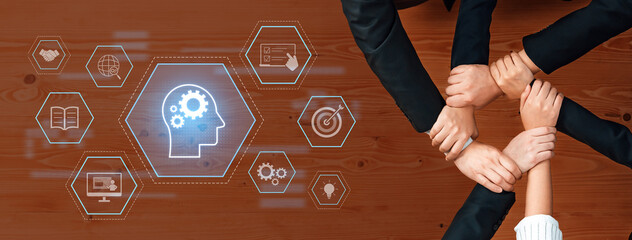 A creative representation of teamwork showcasing diverse hands joining together, surrounded by icons symbolizing innovation, strategy, and support on a wooden surface. Trope
