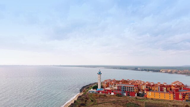 Descending near the Aheloy Lighthouse and colorful Marina Cape Hotel. The Black Sea waterscape at backdrop. Burgas, Bulgaria.