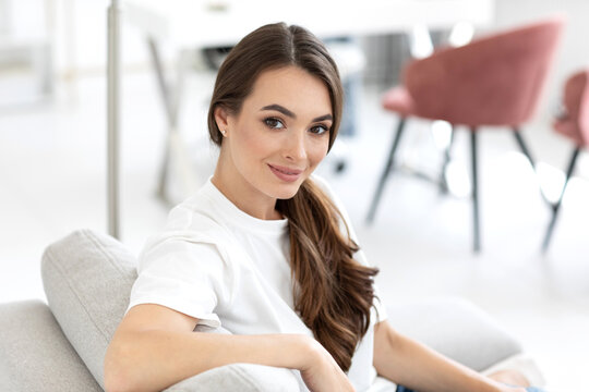Woman in a white shirt is smiling and resting