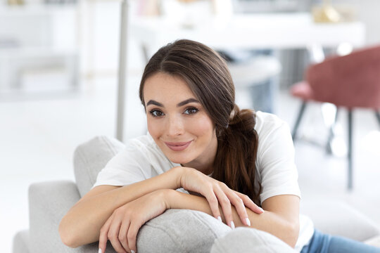 Woman in a white shirt is smiling and resting