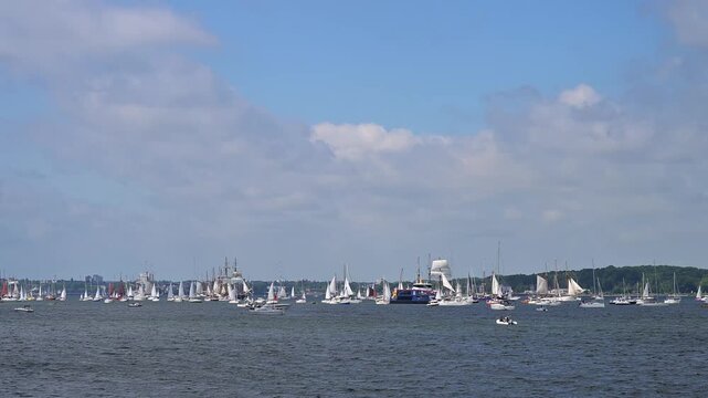 Segelboote und Yachten auf ruhigem Wasser mit bewaldeter K&uuml;stenlinie und bew&ouml;lktem Himmel, Windjammer Parade Kiel 2025, Heikendorf, Kreis Pl&ouml;n, Kieler F&ouml;rde, Schleswig-Holstein, Deutschland, Europa 