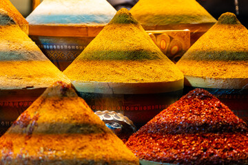 Close-up View of Vibrant Spice Piles in Earth Tones and Orange Hues at an Oriental or Middle Eastern Market