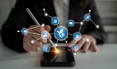 A business person interacts with a smartphone showcasing global connectivity icons, symbolizing modern communication and technology trends in a dynamic workspace. Tessel