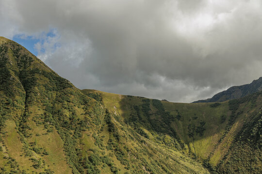 pendii erbosi di una catena montuosa, con cielo nuvoloso, di giorno, in Italia