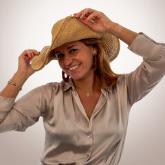 Happy woman in straw cowboy hat smiling at camera