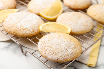 Tasty lemon cookies and fruit slices on white marble table, closeup