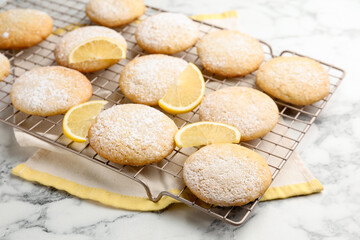 Tasty lemon cookies and fruit slices on white marble table, closeup