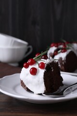 Tasty Christmas cake with cranberries and rosemary served on wooden table, closeup