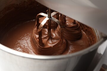 Mixing chocolate dough in bowl, closeup view