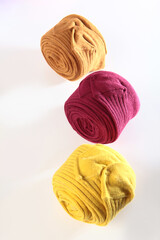 Burgundy and yellow children's tights are rolled up. Colored children's tights. Warm clothes for children.White background.