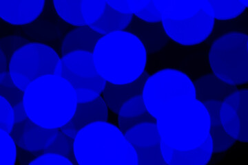 Abstract blue bokeh lights creating soft, dreamy, out-of-focus background. Glowing circular shapes form vibrant, modern visual texture suitable for creative design, holiday themes, digital backdrops