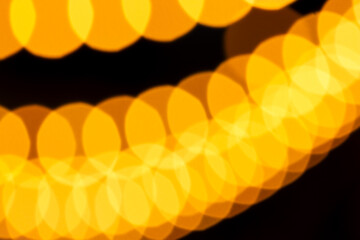 Soft overlapping yellow bokeh circles forming glowing, abstract light patterns against dark backdrop. Dreamy, atmospheric effect suitable for festive designs, creative textures, modern visual concepts