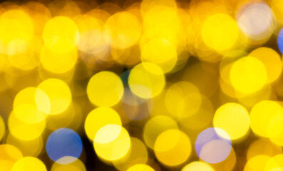 Golden bokeh lights forming warm, soft, out-of-focus background. Texture works well for holiday visuals, creative designs, digital backdrops, dreamy atmosphere, glowing yellow circles create festive