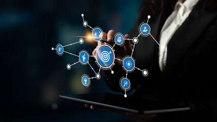 A professional businesswoman engages with a digital network interface on a touchscreen, illustrating the intersection of technology and data management in a modern office environment. Tessel