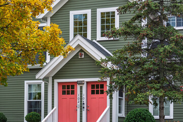 A charming twin-door family home with autumn trees and classic architectural details in the Brighton area of Boston, Massachusetts, USA
