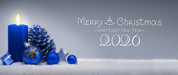 Blue Advent candle with Christmas decoration isolated on gray.