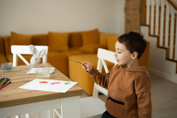 Toddler painting with joy at a wooden table