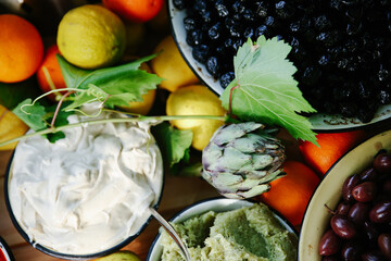 Full Overhead View of a Rustic Catering Spread Featuring Hearty Shakshuka, Fresh Quinoa Salad with Almonds, and Creamy Polenta with Cheese Shavings