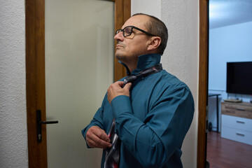 Man adjusts necktie for work