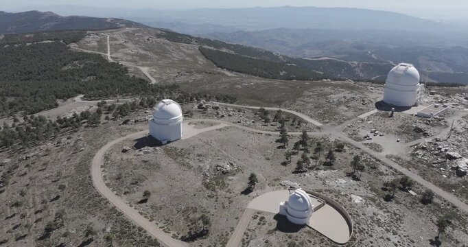 Aerial drone shot of Calar Alto Observatory telescopes in the Sierra de Los Filabres mountain range in Almeria, Andalusia, Spain. Largest astronomical observatory in Europe. Sunny, clear blue sky 
