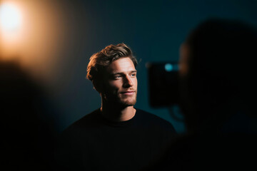 Handsome Man Smiling in Film Studio Lighting During Interview or Video Shoot
