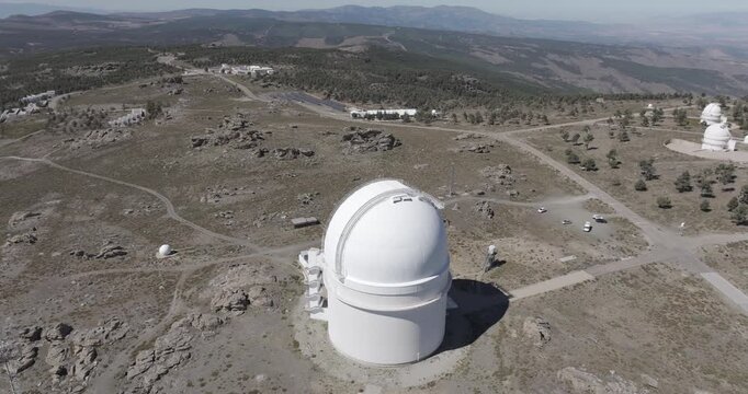 Aerial drone shot of Calar Alto Observatory telescopes and solar panels in the Sierra de Los Filabres mountain range in Almeria, Andalusia, Spain. Largest observatory in Europe. Sunny, clear blue sky 