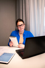 Working remotely from cozy home interior. Woman enjoys location-independent work with laptop in comfortable home settings. Freedom and flexibility of working from anywhere. Modern technology concept