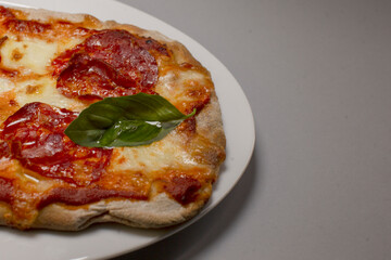 pepperoni pizza slice with basil leaf, golden melted cheese and crisp charred crust, hearty comfort snack ideal for casual